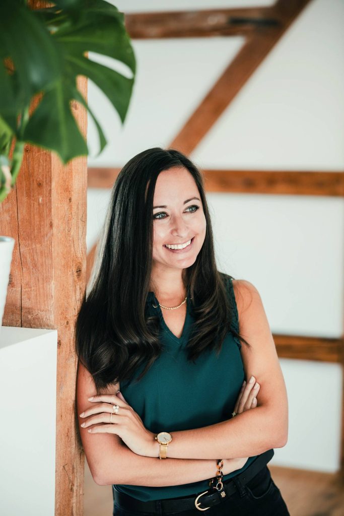 Veronika Mennel lächelnd im Büro, professionelle Texterin für kreative Werbetexte und Storytelling